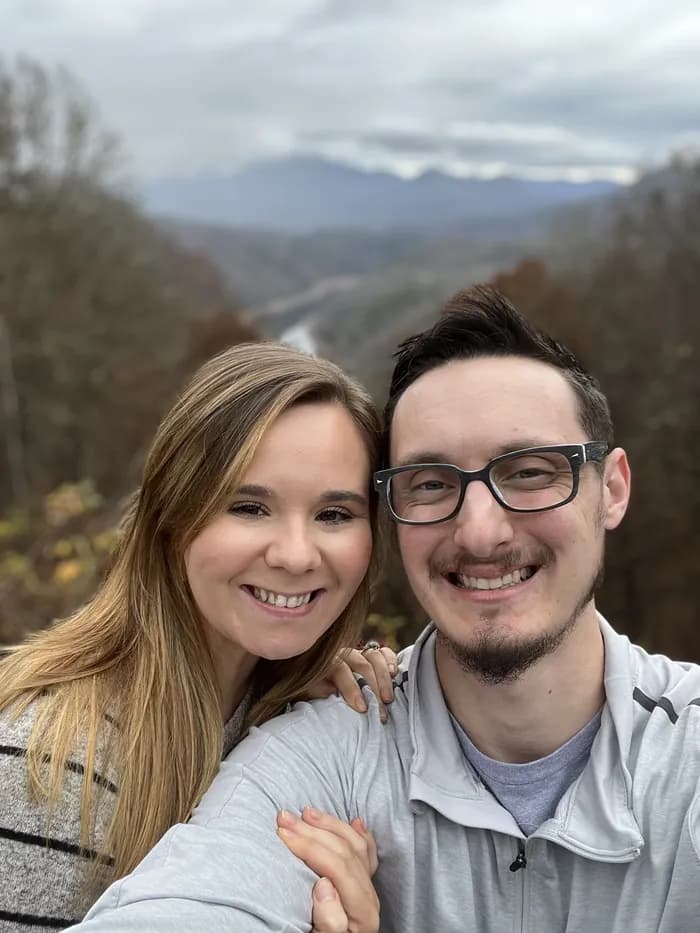 Matthew Wood and his wife outdoors, smiling in front of a mountain valley